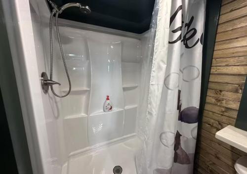 une douche dans une salle de bain avec un rideau de douche blanc dans l'établissement Sunrise, Mountain & Farm View - Heated Tub or Pool, à Mentone