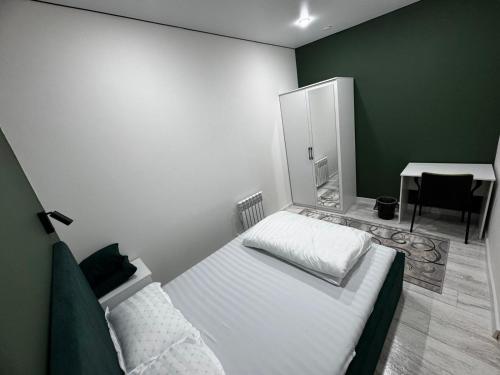 une chambre avec un lit, une table et un bureau dans l'établissement Qonys Hostel, à Atyraū