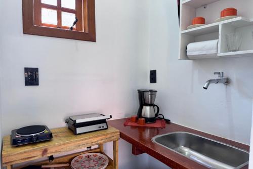 cocina con fregadero y barra con licuadora en Estúdios Sol e Mar, aconchego e charme em Tucuns, en Búzios