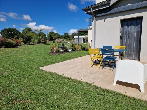 a patio with a table and chairs in a yard at Le Gîte "Aubrac" Haut de gamme, Jardin, Piscine in Gabriac