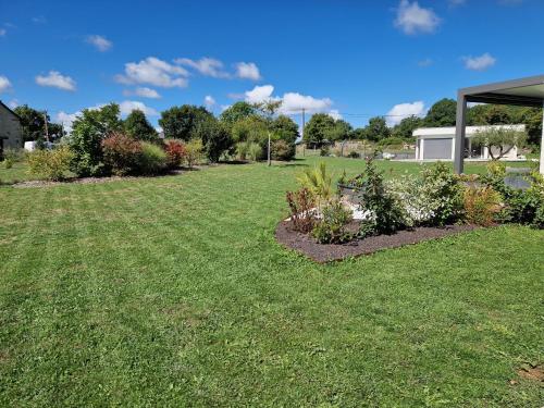 a yard with some plants in the grass at Le Gîte "Aubrac" Haut de gamme, Jardin, Piscine in Gabriac
