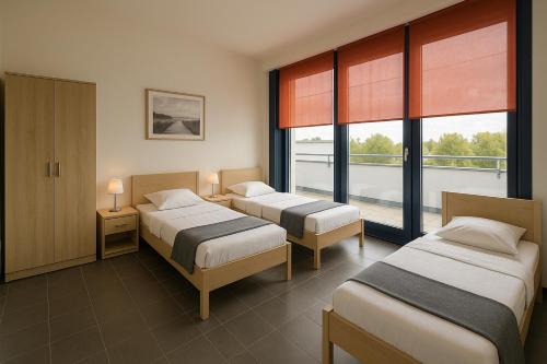 deux lits dans une chambre avec deux fenêtres dans l'établissement Monteur- und Ferienunterkunft Ludwigsfelde, à Ludwigsfelde