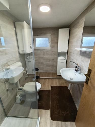 a bathroom with two sinks and a toilet and a shower at Divan Vlašić in Šišava