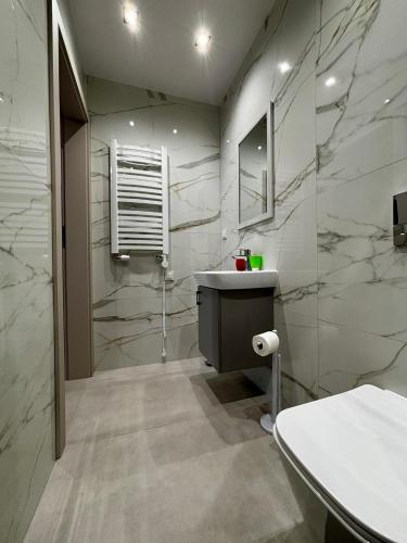 a bathroom with a sink and a mirror at Pokoje gościnne Denega in Jastarnia