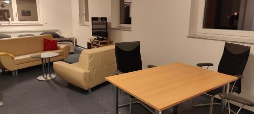 Ein Wartezimmer mit Sofas, Tischen und einem Fernseher in der Unterkunft Family Room Grüne Auszeit Dresden in Dresden