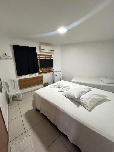 a bedroom with a large white bed and a window at Pousada Ramon in Remígio