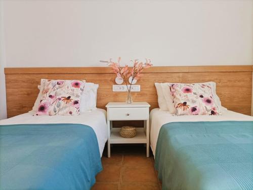 Casa Buena Vista - Rural Oasis في Alajeró: سريرين يجلسان بجانب بعضهما البعض في غرفة