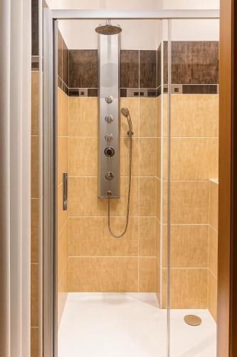 a shower with a glass door at Budovatelska Apartment in Bratislava