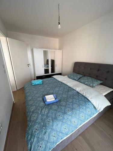 a bedroom with a large bed with a blue blanket at Cloche d Or modern 2 bed in Luxembourg