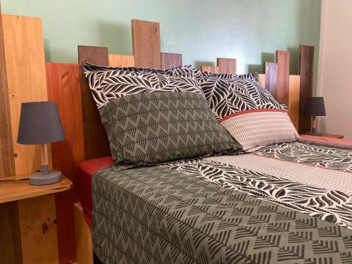 a bed with black and white sheets and pillows at Ti Zeinga la in Sainte-Anne