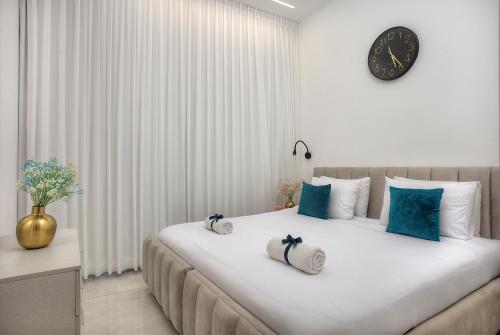 Un dormitorio con una cama grande con un reloj en la pared. en Mountain Top Views -203- נופי פסגות, en Safed