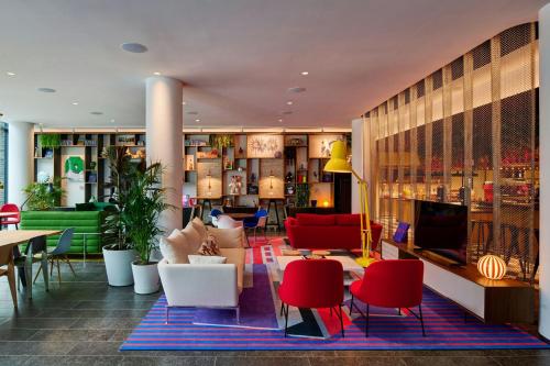 a lobby with red and white chairs and tables at citizenM Dublin St Patrick's in Dublin