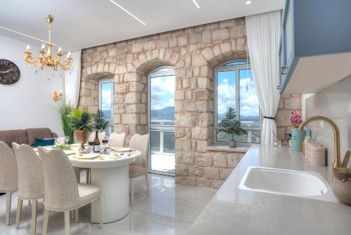 Una cocina y un comedor con mesa y sillas. en Mountain Top Views -203- נופי פסגות, en Safed