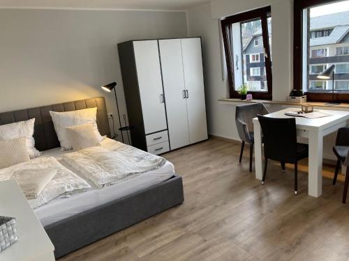 ein Schlafzimmer mit einem Bett, einem Schreibtisch und einem Tisch in der Unterkunft Ferienwohnungen Albers in Winterberg