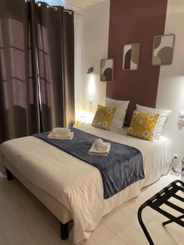 a bedroom with a large bed with two hats on it at Le logis Katia in Saumur