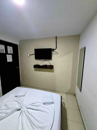 a bedroom with a bed with a tv on the wall at Casa ALCATRAZ in Cartagena de Indias