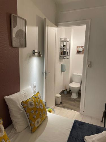 a bedroom with a bed and a bathroom with a toilet at Le logis Katia in Saumur