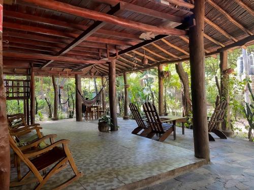 un pabellón con sillas, mesa y árboles en Marumar, en Popoyo