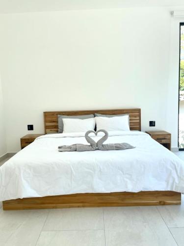 a white bed with a heart decoration on it at Casa McCash in Tamarindo