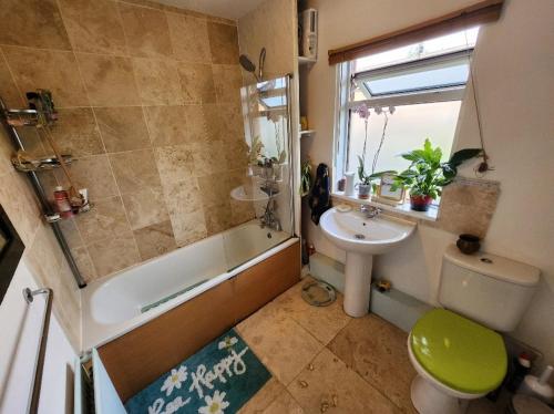 a bathroom with a sink and a tub and a toilet at BEE GENTLE BEE KIND BEE HAPPY rooms in Glastonbury