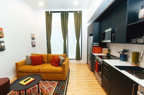 ein Wohnzimmer mit Couch und Küche in der Unterkunft Loft 306 - The WIlliam - Atrium - Downtown Vibes in Birmingham