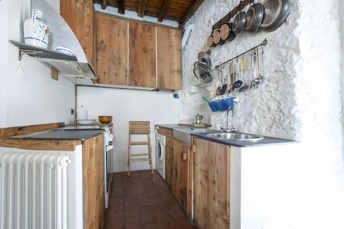 a kitchen with wooden cabinets and a stone wall at Casa Nemo - Riomaggiore, 5 Terre in Riomaggiore