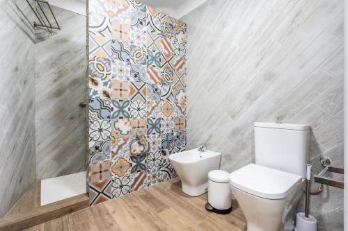 ein Badezimmer mit einem WC und einer Mosaikwand in der Unterkunft El Rinconcito con Vistas al Mar in Los Menores