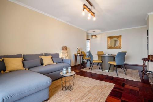 a living room with a blue couch and a table at Nata7 Apartment in Funchal