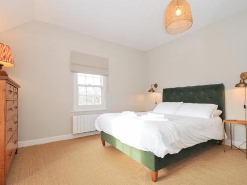 um quarto com uma grande cama branca e uma janela em Mermaid Cottage em Port Isaac