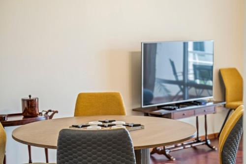 a room with a table and a tv and chairs at Nata7 Apartment in Funchal
