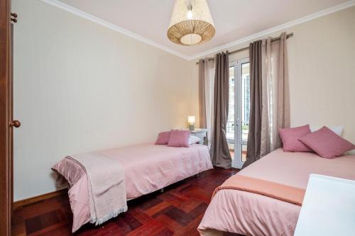 a bedroom with two beds with pink sheets at Nata7 Apartment in Funchal
