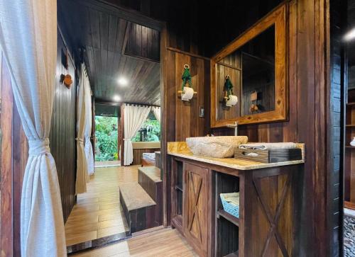 ein Badezimmer mit einem Waschbecken und Holzwänden in der Unterkunft TROPICAL GARDEN Homestay in Buôn Alê (1)
