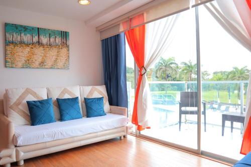 Una sala de estar con un sofá y una ventana grande. en Oceanfront Studio Beach and Pool, en María Chiquita