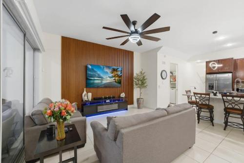 a living room with a couch and a ceiling fan at Tranquil Times Townhouse 4 bed Private Pool in Davenport
