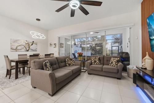 a living room with two couches and a dining room at Tranquil Times Townhouse 4 bed Private Pool in Davenport
