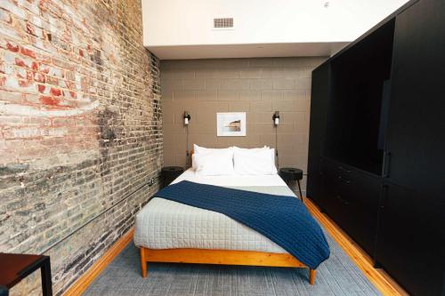 a bedroom with a bed and a brick wall at Loft 308 - The William - Views over Carrigans in Birmingham
