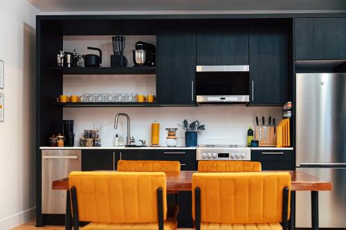 a kitchen with a wooden table and orange chairs at Loft 308 - The William - Views over Carrigans in Birmingham
