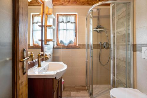 une salle de bain avec lavabo et douche dans l'établissement Baita Chalet Alabama, à Rocca