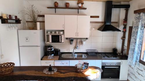 a kitchen with white cabinets and a sink at La María de Tortas in Paterna del Madera