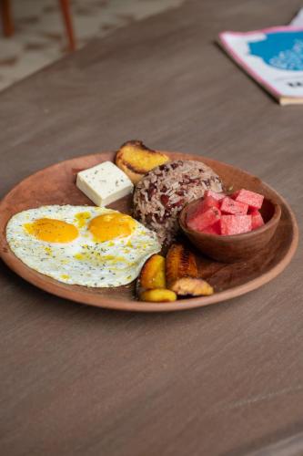 une assiette de nourriture avec des œufs et des fruits sur une table dans l'établissement Casa Nära Hotel, à El Sucio