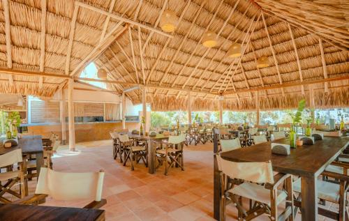 a restaurant with tables and chairs and a large ceiling at Santuario Playa Bonita in Buritaca