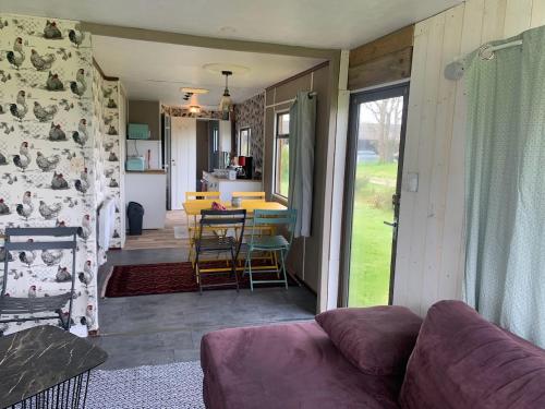 un salon avec un canapé et une cuisine dans l'établissement Mobil Home Vintage à la Ferme des buttons, à Rosnay
