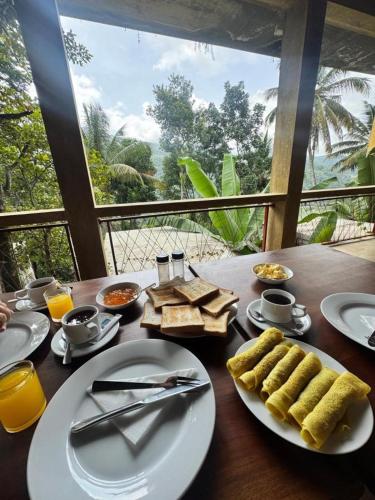 uma mesa de madeira com pratos de comida sobre ela em Kandy Bird Villas em Kandy