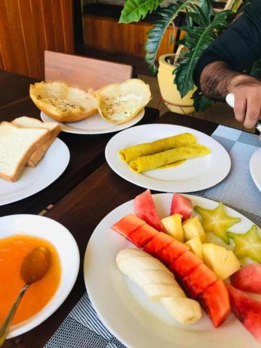 uma mesa com pratos de frutas e produtos hortícolas em Kandy Bird Villas em Kandy