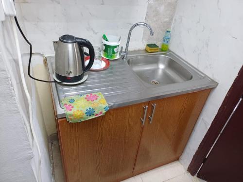 eine Küchenspüle mit Kaffeemaschine darüber in der Unterkunft Fully Furnished Modern Studio in a Prime Location beside Abu Dhabi Central Bus Station and Al Wahda Mall العربية استوديو حديث ومفروش بالكامل في موقع مميز بجوار محطة الحافلات المركزية ومول الوحدة في أبوظبي in Abu Dhabi