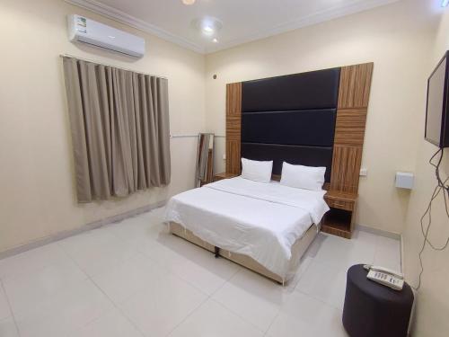 哈伊勒روعة أجا للشقق المخدومة的卧室里有一张白色的床和一台电视