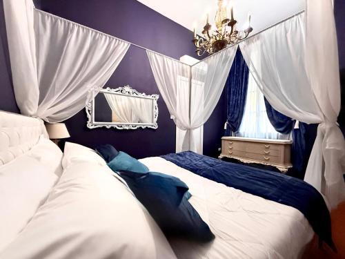 une chambre avec deux lits, un miroir et un lustre dans l'établissement Villa Meraville, à Bologne