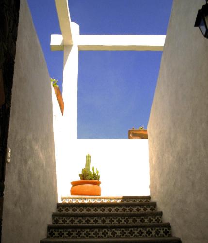 a stairway with a cross and a potted plant at Hotel El Portón in Tenancingo de Degollado