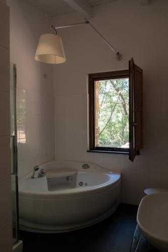 a large white tub in a bathroom with a window at il cannito in Capaccio-Paestum