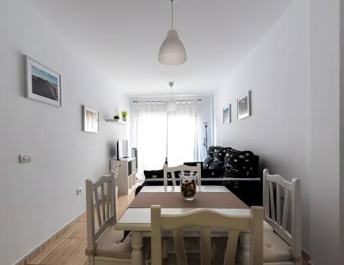 Un comedor y una sala de estar con mesa y sillas. en Casa Nana, en Playa de Santiago
